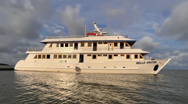 The Belle Amazon multi-deck river cruise ship moored on calm water under a dramatic cloudy sky, part of the Amazon cruise from Alter do Chão experience