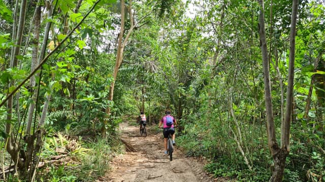 Twee fietsers op een smal onverhard pad door het dichte Atlantische woud bij Itacaré tijdens een fietsvakantie in Bahia