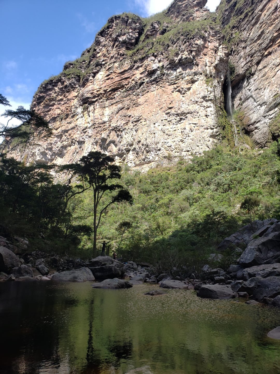 Un escursionista sotto l'alta cascata del Cachoeirão, nella Chapada Diamantina