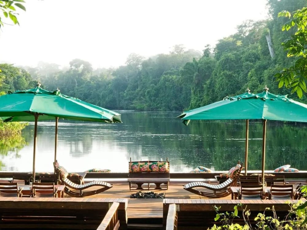 Lounge chairs and green umbrellas on the floating deck at Cristalino Lodge, an amazing Amazon eco lodge in Brazil.