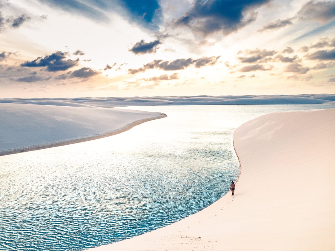 Escursionisti attraversano le dune e le lagune d'acqua dolce dei Lençóis Maranhenses, in Brasile