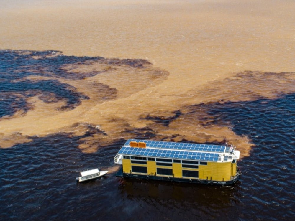Ripresa aerea della barca Untamed Amazon con i pannelli solari sul tetto, che mostrano il suo sistema energetico ecologico e il design sostenibile.