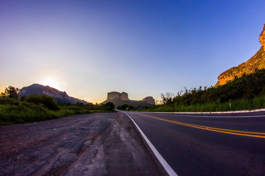 Strada asfaltata deserta che porta verso le montagne della Chapada Diamantina, in Bahia, all'alba.