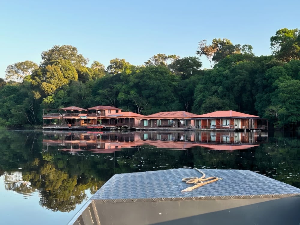 Lodge flotante ecológico de tejados rojos reflejado en el Río Negro, en el Amazonas brasileño