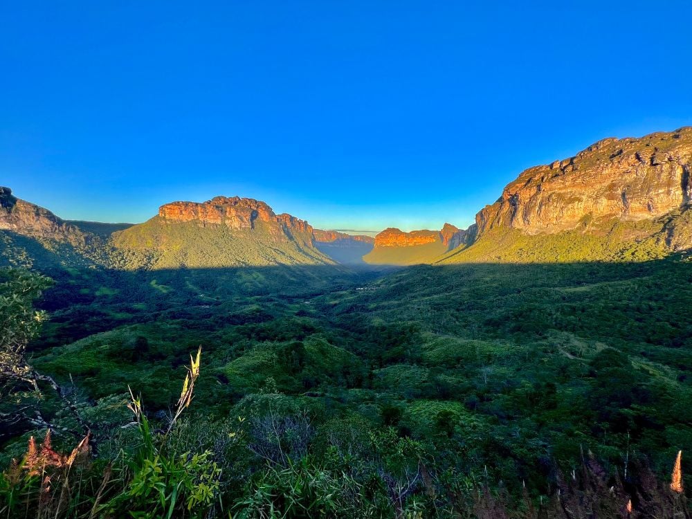 Panoramic view of a lush green valley and flat-topped mountains in Chapada Diamantina National Park at sunrise. Panoramic view of a lush green valley and flat-topped mountains in Chapada Diamantina National Park at sunrise.