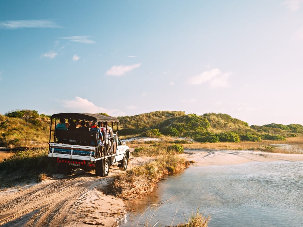 Un veicolo 4x4 porta i turisti lungo una pista sabbiosa, verso l'ingresso del Parco Nazionale dei Lençóis Maranhenses. Un veicolo 4x4 porta i turisti lungo una pista sabbiosa, verso l'ingresso del Parco Nazionale dei Lençóis Maranhenses.