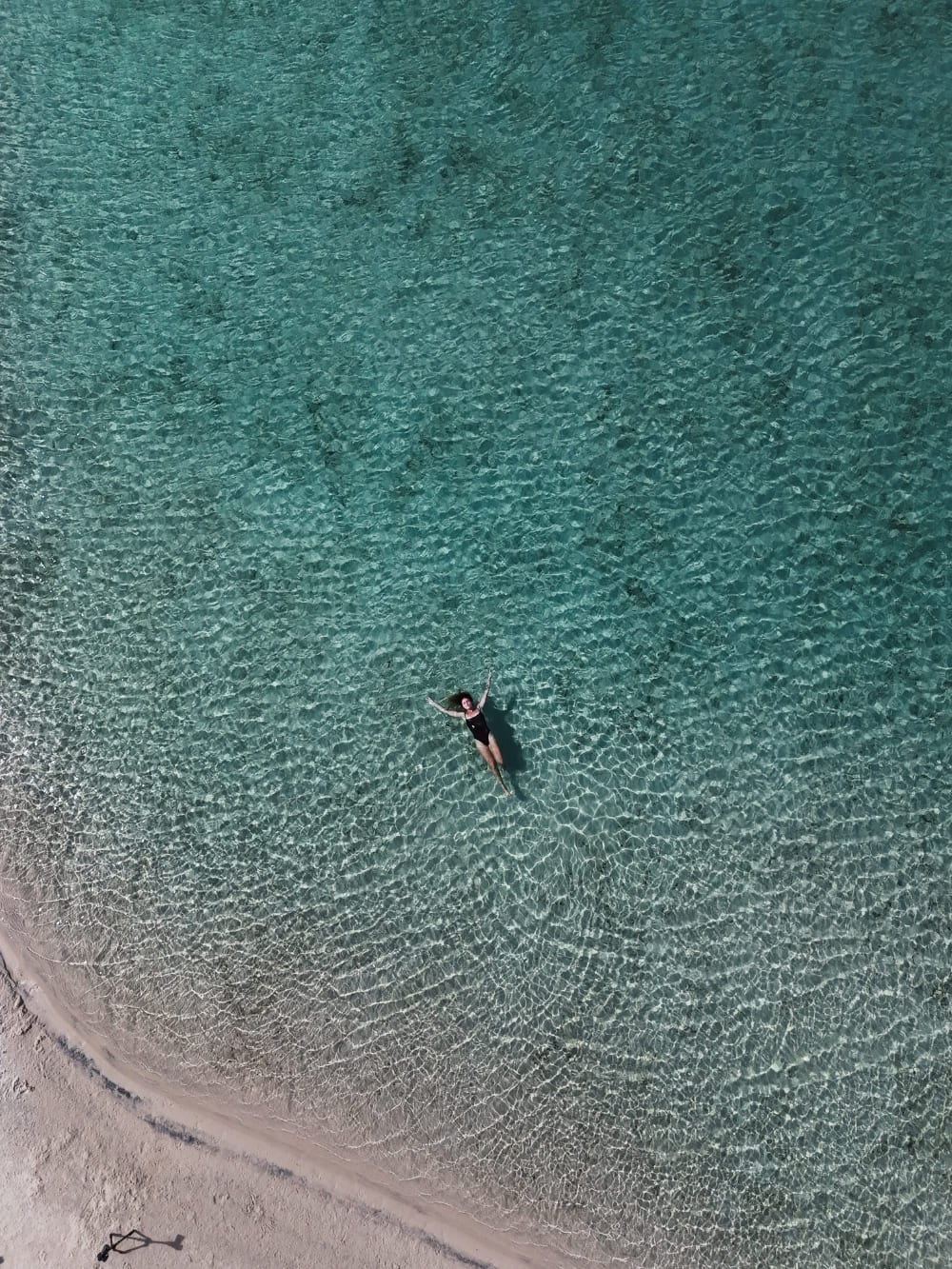 Una persona nuota e si rilassa nelle acque cristalline di una laguna dei Lençóis Maranhenses. Una persona nuota e si rilassa nelle acque cristalline di una laguna dei Lençóis Maranhenses.