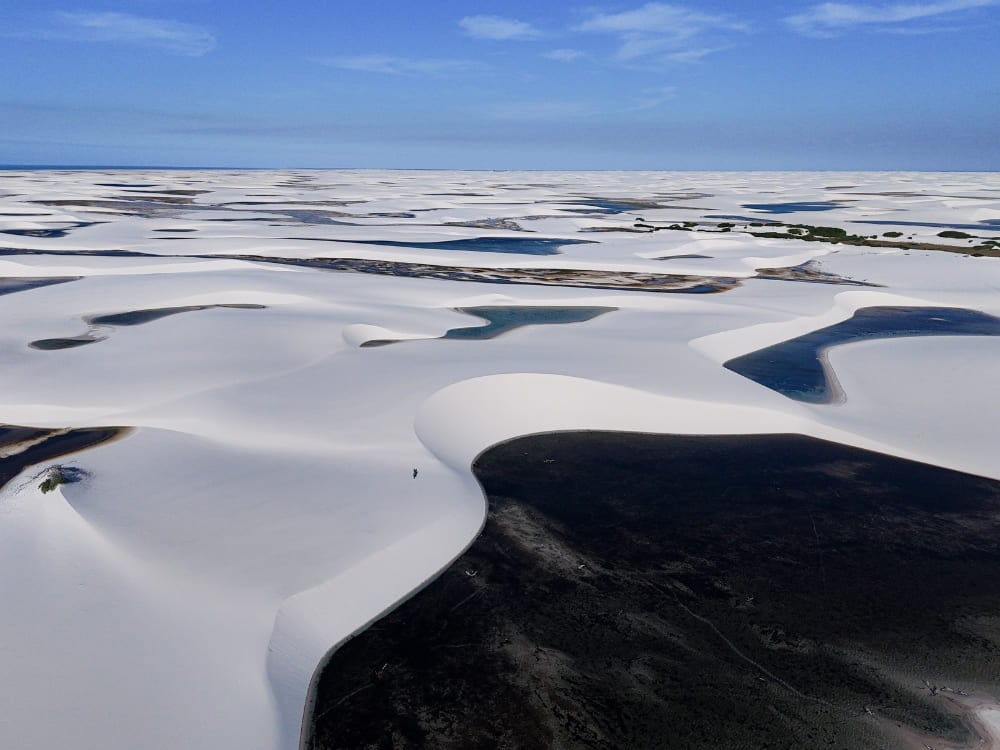 Un ampio panorama mostra migliaia di lagune di acqua piovana tra le dune di sabbia bianca. Un ampio panorama mostra migliaia di lagune di acqua piovana tra le dune di sabbia bianca.