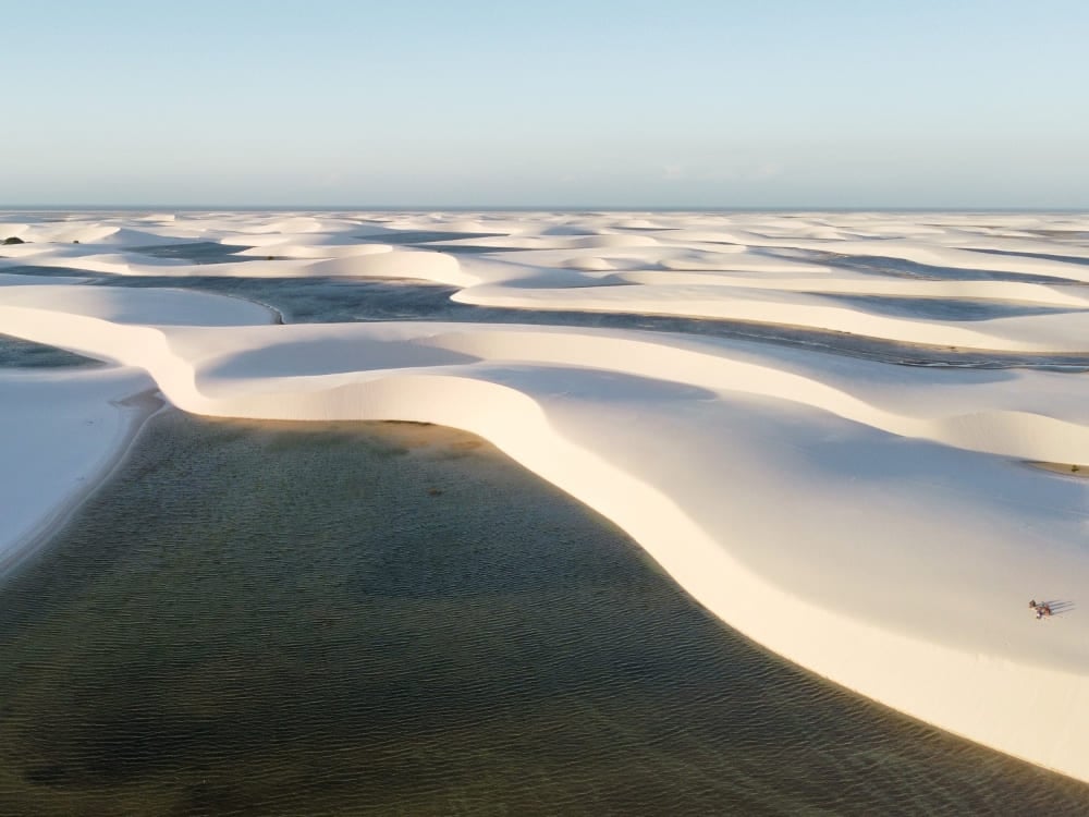 Vista aérea de las dunas de arena blanca activas y las lagunas de agua de lluvia de los Lençóis Maranhenses, que se extienden hasta el horizonte. Vista aérea de las dunas de arena blanca activas y las lagunas de agua de lluvia de los Lençóis Maranhenses, que se extienden hasta el horizonte.