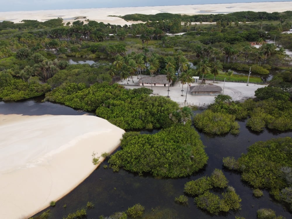 Casas pequeñas rodeadas de vegetación nativa frondosa y dunas de arena inactivas en los Lençóis Maranhenses. Casas pequeñas rodeadas de vegetación nativa frondosa y dunas de arena inactivas en los Lençóis Maranhenses.