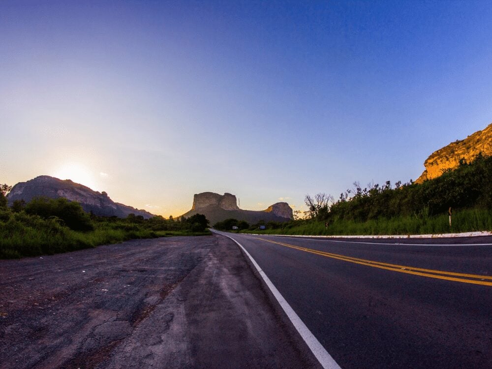 Una strada asfaltata deserta punta dritta verso il Morro do Pai Inácio, sotto un cielo azzurro all'imbrunire. Una strada asfaltata deserta punta dritta verso il Morro do Pai Inácio, sotto un cielo azzurro all'imbrunire.