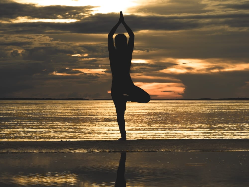 Silhouette di una persona nella posizione yoga dell'albero su una spiaggia fluviale amazzonica al tramonto. Silhouette di una persona nella posizione yoga dell'albero su una spiaggia fluviale amazzonica al tramonto.