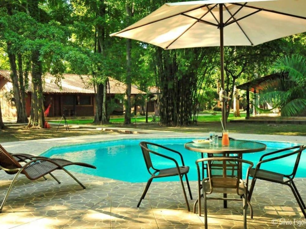 Lounge chairs sit beside the outdoor swimming pool at Aymara lodge, an ecological refuge surrounded by untouched nature. Lounge chairs sit beside the outdoor swimming pool at Aymara lodge, an ecological refuge surrounded by untouched nature.