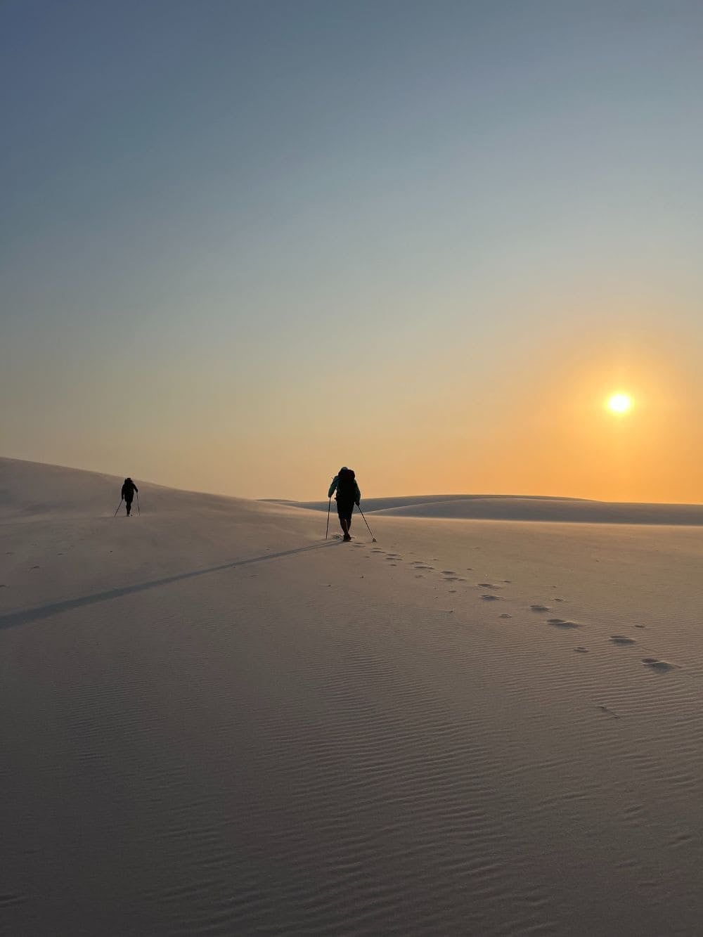 Persone in controluce camminano sulle dune di sabbia dei Lençóis Maranhenses al tramonto. Persone in controluce camminano sulle dune di sabbia dei Lençóis Maranhenses al tramonto.