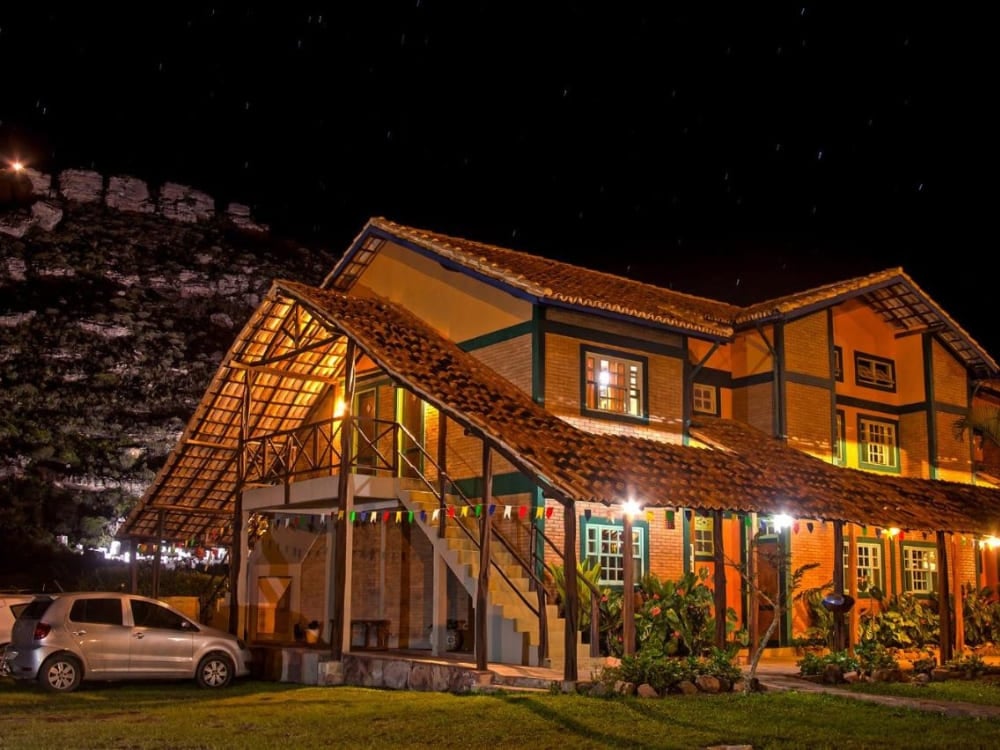 Esterno rustico della Pousada Monte Azul a Mucugê, illuminato di notte sotto un cielo scuro. Esterno rustico della Pousada Monte Azul a Mucugê, illuminato di notte sotto un cielo scuro.