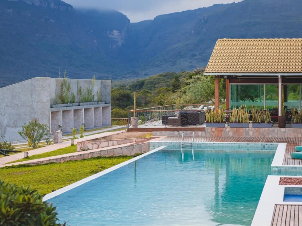Piscina moderna e architettura raffinata in cemento della Pousada Amanhecer, affacciata sulle montagne del Vale do Capão. Piscina moderna e architettura raffinata in cemento della Pousada Amanhecer, affacciata sulle montagne del Vale do Capão.
