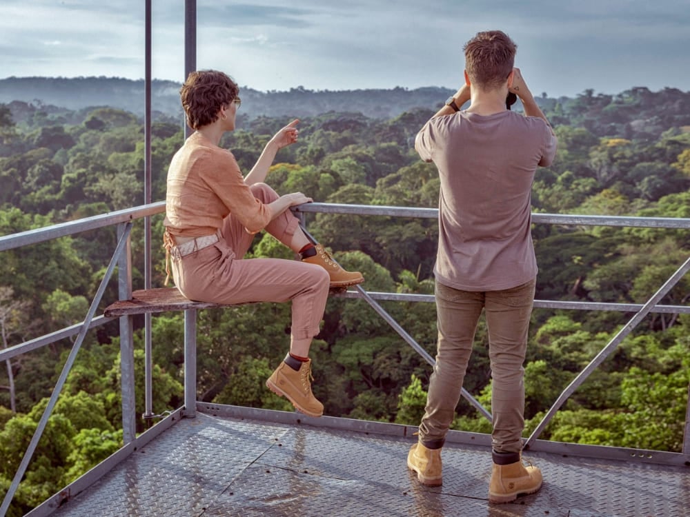 Travelers using binoculars on an observation tower high above the canopy to safely spot birds and wildlife in the Amazon Rainforest. Travelers using binoculars on an observation tower high above the canopy to safely spot birds and wildlife in the Amazon Rainforest.