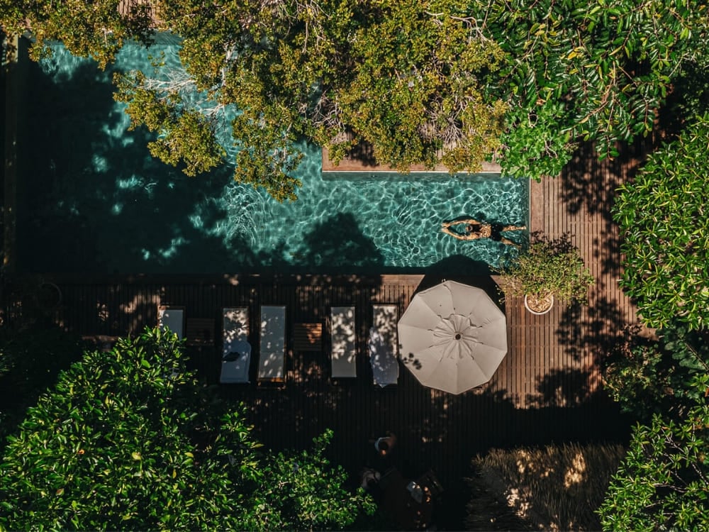 Aerial view of a swimming pool at a luxury eco-lodge nestled deep within the Amazon Rainforest vegetation, offering leisure in nature. Aerial view of a swimming pool at a luxury eco-lodge nestled deep within the Amazon Rainforest vegetation, offering leisure in nature.