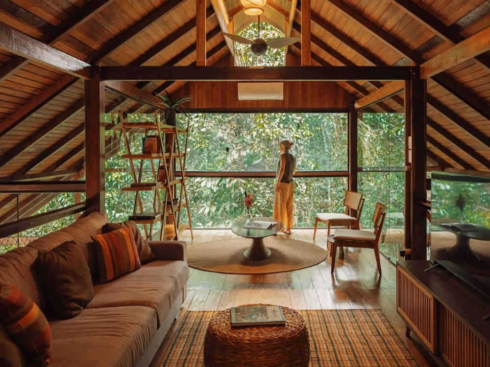 Cozy lounge area inside an Amazon jungle lodge with large glass windows offering immersive views of the surrounding dense forest. Best Amazon Jungle Cozy lounge area inside an Amazon jungle lodge with large glass windows offering immersive views of the surrounding dense forest.