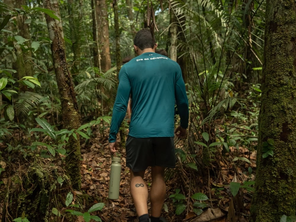 Un viaggiatore cammina nella giungla verde e fitta e vive l'ecoturismo in Amazzonia in prima persona. Un viaggiatore cammina nella giungla verde e fitta e vive l'ecoturismo in Amazzonia in prima persona.