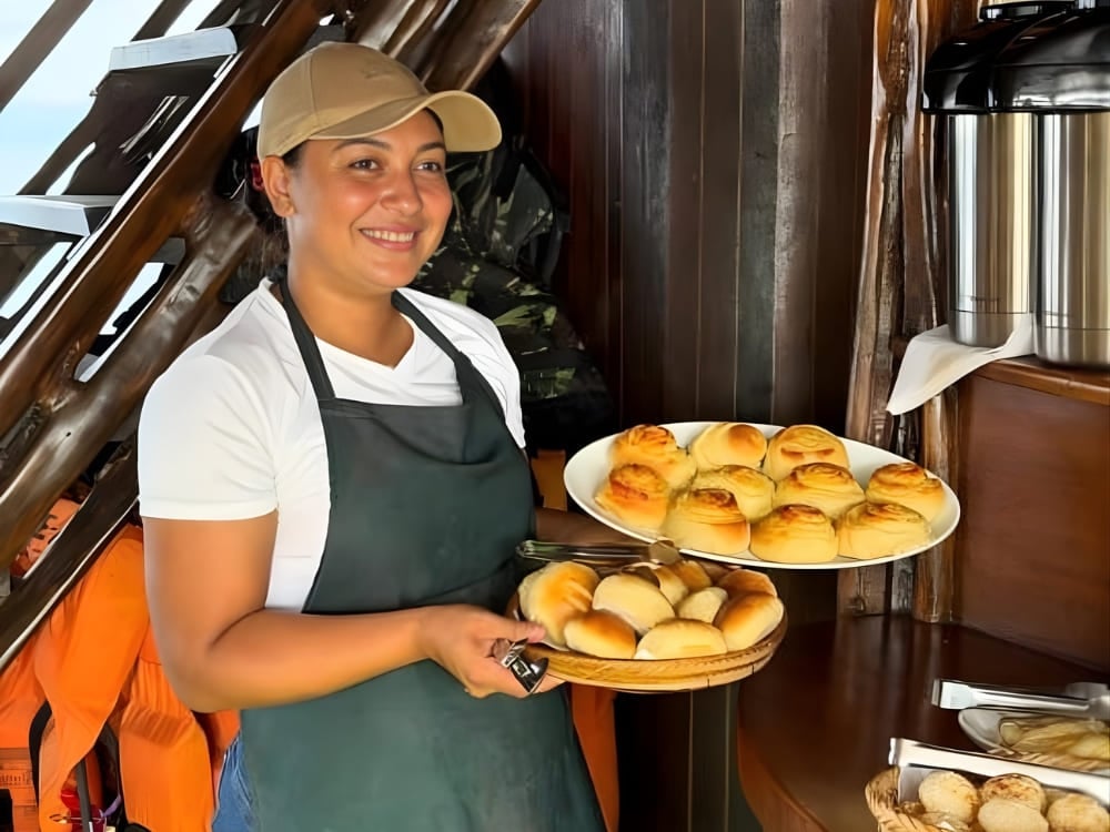 Donna con il grembiule che tiene dei piatti con pane fresco a bordo di un'imbarcazione, a rappresentare l'indipendenza economica femminile conquistata grazie al turismo. Donna con il grembiule che tiene dei piatti con pane fresco a bordo di un'imbarcazione, a rappresentare l'indipendenza economica femminile conquistata grazie al turismo.