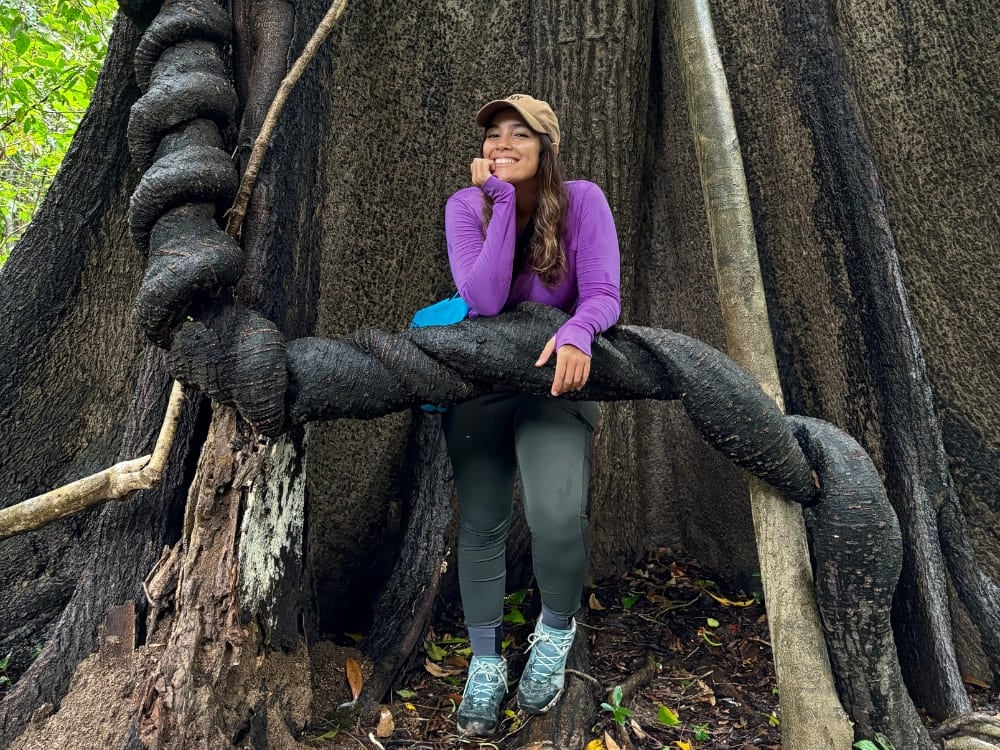 Mariana si riposa su una gigantesca radice contorta mentre esplora il verde fitto della giungla amazzonica. Mariana si riposa su una gigantesca radice contorta mentre esplora il verde fitto della giungla amazzonica.