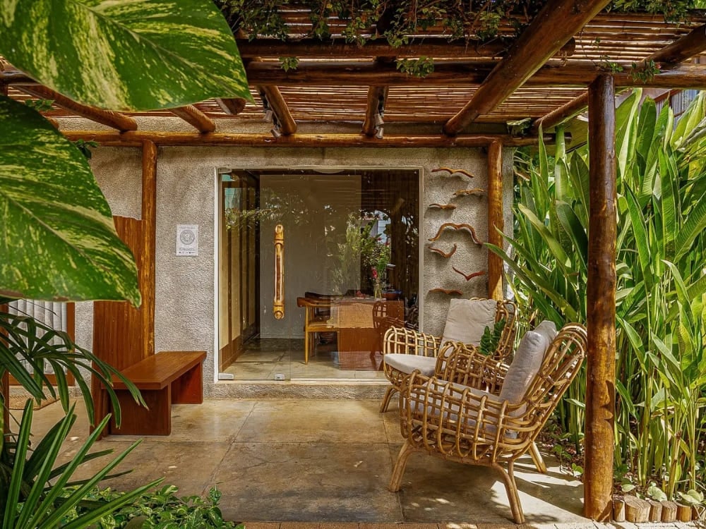 Charming suite balcony with a wooden pergola, wicker chairs, and tropical plants. Charming suite balcony with a wooden pergola, wicker chairs, and tropical plants.