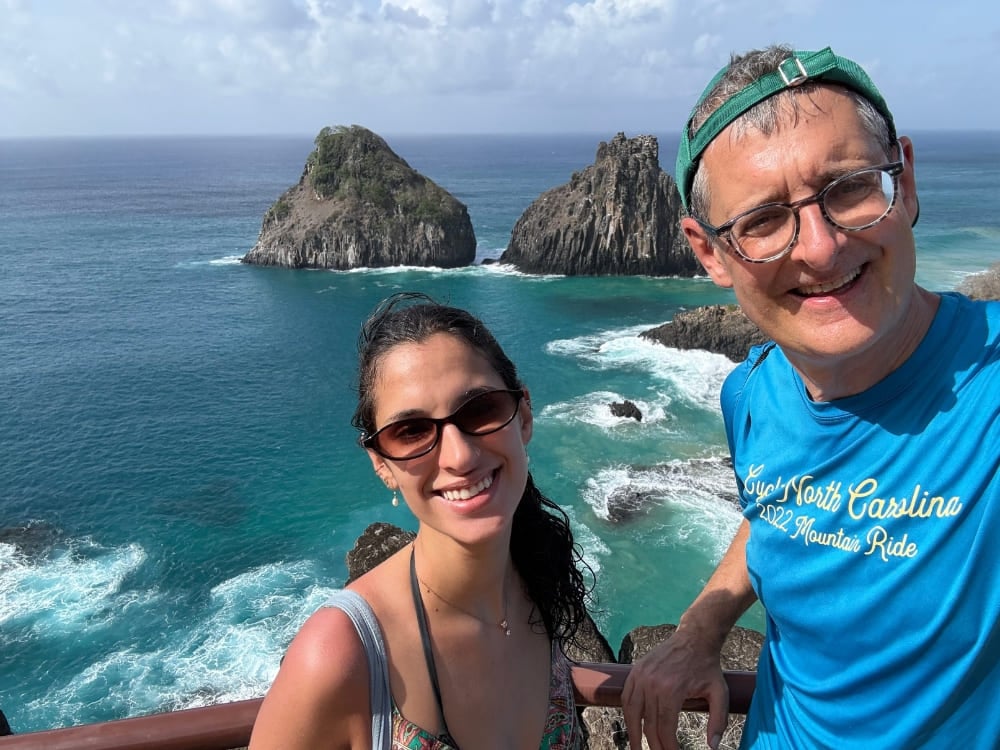 Father and daughter smiling for a selfie at a viewpoint overlooking the turquoise ocean and the iconic Morro Dois Irmãos rock formations. Father and daughter smiling for a selfie at a viewpoint overlooking the turquoise ocean and the iconic Morro Dois Irmãos rock formations.