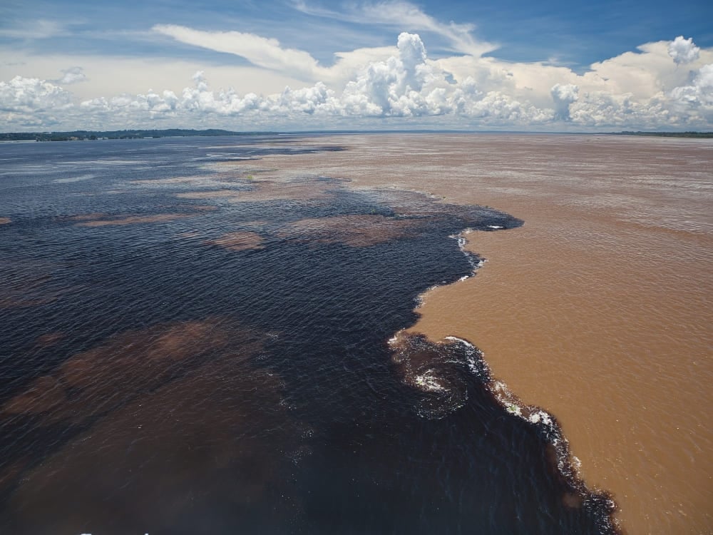 Vista aérea del Encuentro de las Aguas, donde el oscuro Rio Negro corre junto al turbio río Solimões sin mezclarse. Vista aérea del Encuentro de las Aguas, donde el oscuro Rio Negro corre junto al turbio río Solimões sin mezclarse.