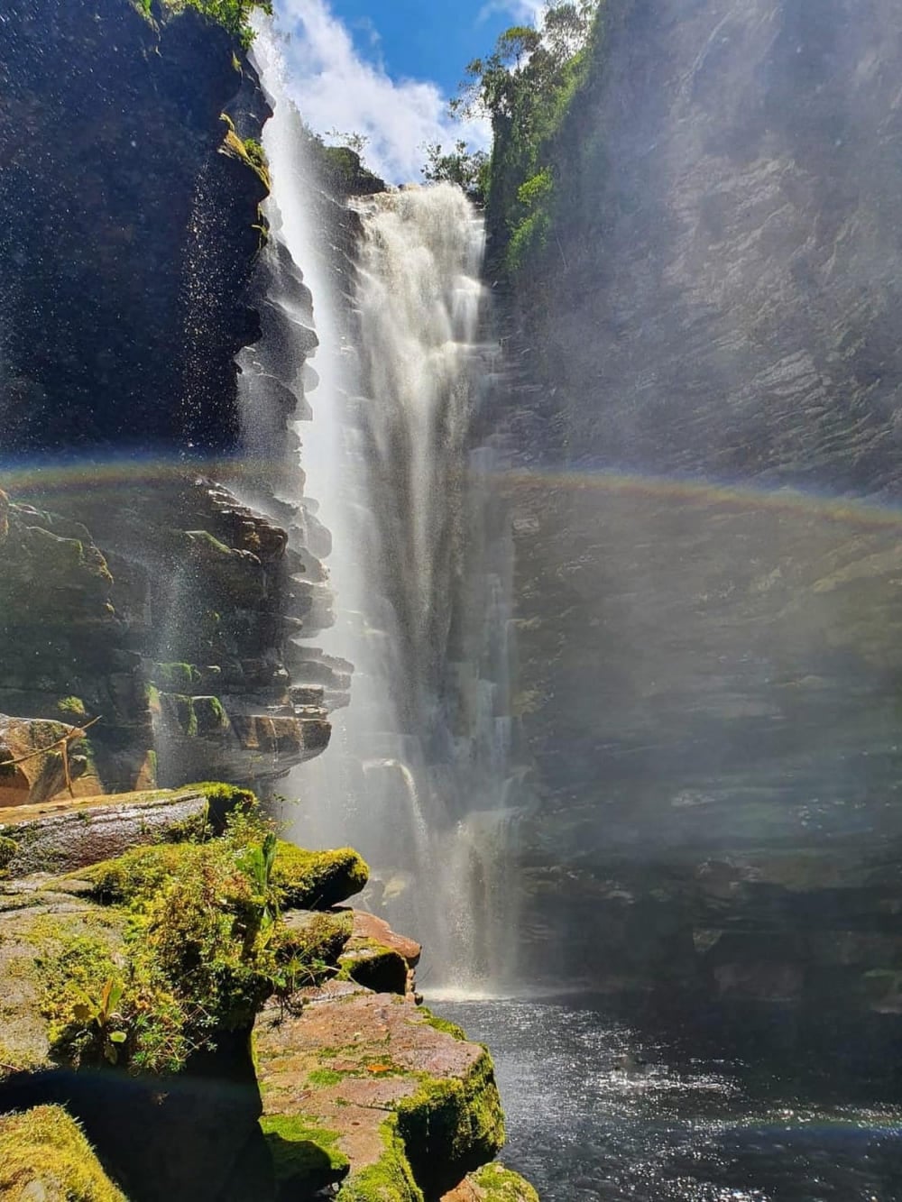 Un arcobaleno acceso si forma nella nebbia della cascata do Mixila, un salto di 80 metri nascosto dentro un canyon stretto e roccioso. Un arcobaleno acceso si forma nella nebbia della cascata do Mixila, un salto di 80 metri nascosto dentro un canyon stretto e roccioso.