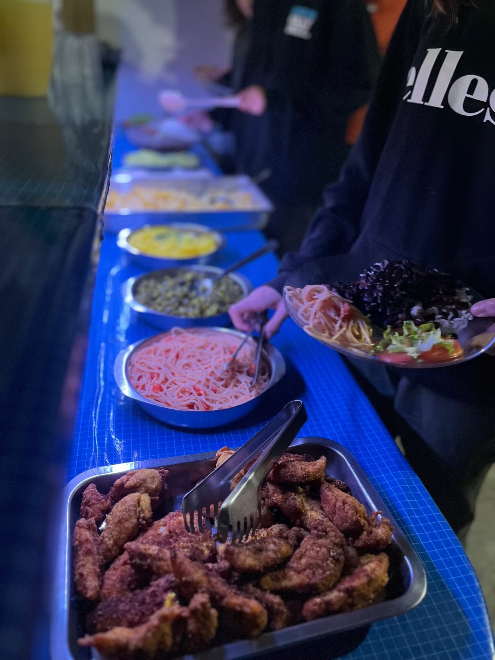 Nach acht Stunden Wanderung schmeckt selbst gekochtes Essen wie ein Festmahl. Ein langer Buffettisch mit mehreren Gerichten, darunter paniertes gebratenes Fleisch, Pasta mit Tomatensauce, Linsen und frischem Salat, serviert in einer lokalen Unterkunft beim Chapada-Diamantina-Trek