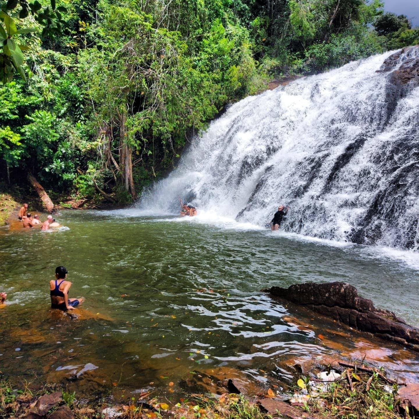 Räder abgestellt, Schuhe aus, alle rein. Manche Belohnungen muss man erschwimmen. Reisende schwimmen im Naturpool des Milagrosa-Wasserfalls, einer breiten Kaskade über dunklem Fels, umgeben von atlantischem Regenwald, auf der Fahrradroute durch Bahia