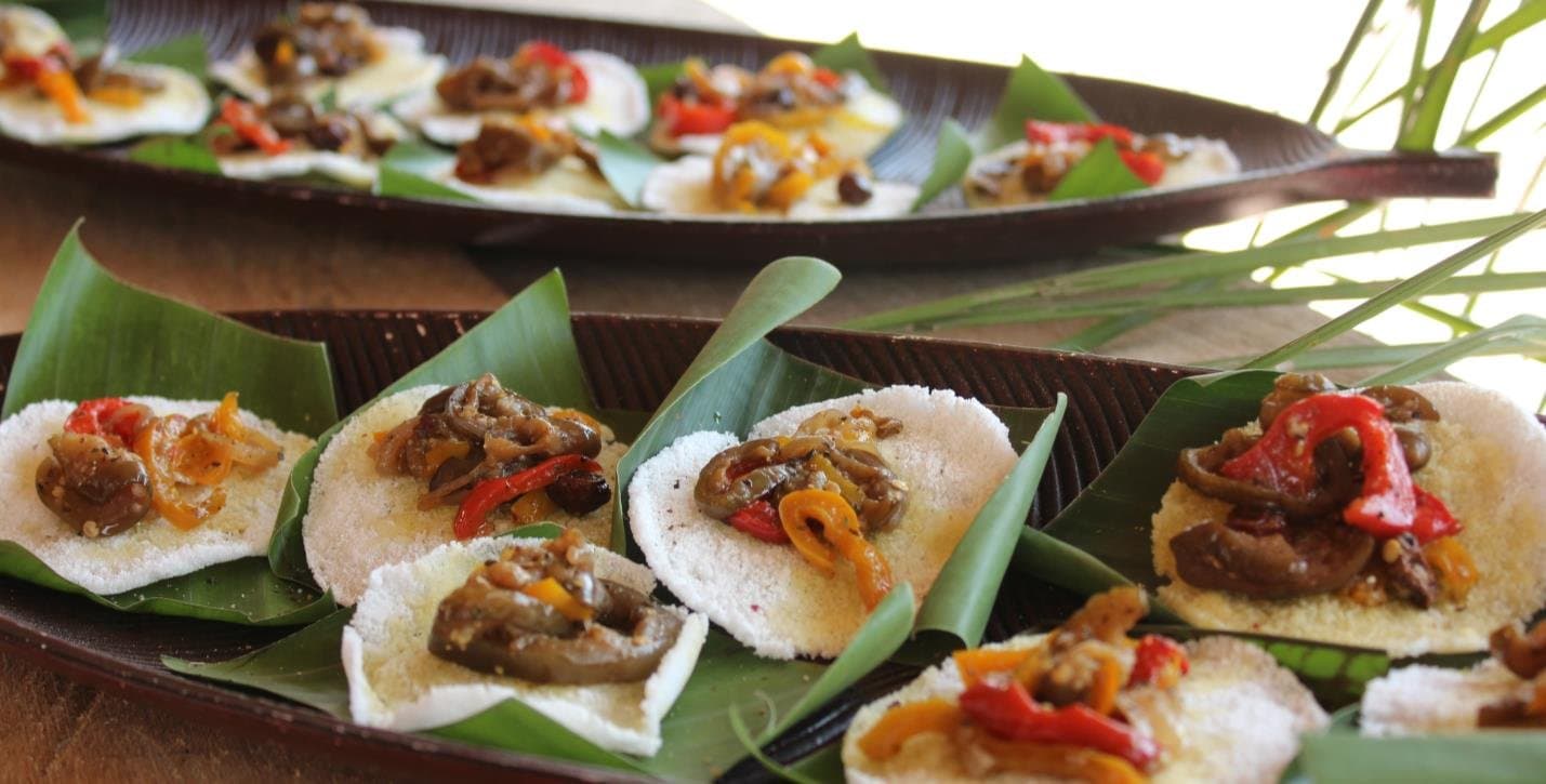 Lokale Zutaten, mit Sorgfalt zubereitet, so schmeckt der Amazonas. Kleine weiße Maniokscheiben mit sautiertem Gemüse und Paprika, auf Bananenblättern angerichtet, bei einer Amazonas-Kreuzfahrt ab Alter do Chão