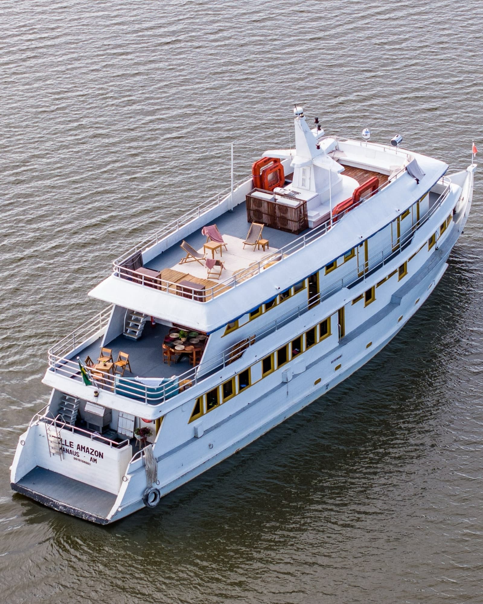 Das Schiff, das Sie durch den Amazonas trägt, von oben betrachtet. Luftaufnahme des Flusskreuzfahrtschiffs Belle Amazon auf dem Amazonas mit offenen Sonnendecks und Liegestühlen auf mehreren Ebenen