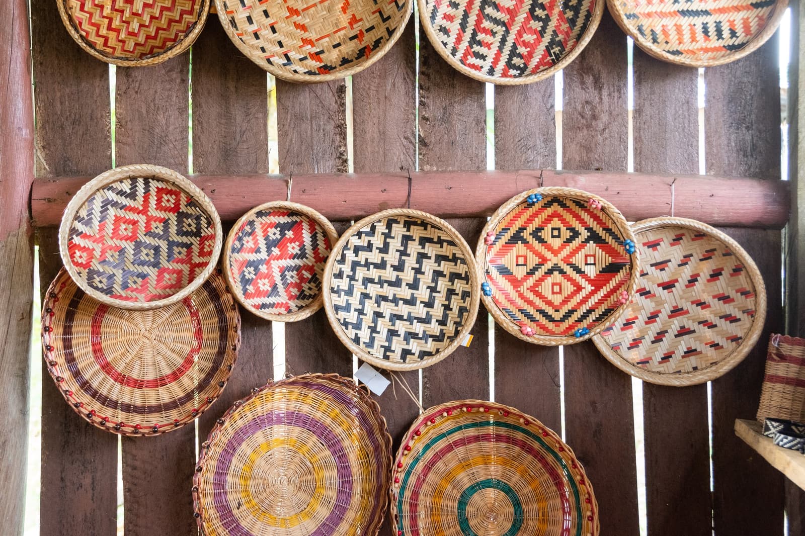 Jedes Muster trägt eine Geschichte, jeder Korb eine andere Hand. Eine Wand mit bunten handgewebten runden Körben mit geometrischen und konzentrischen Mustern in einer Gemeinschaft in der Nähe der Anavilhanas Jungle Lodge Brasilien