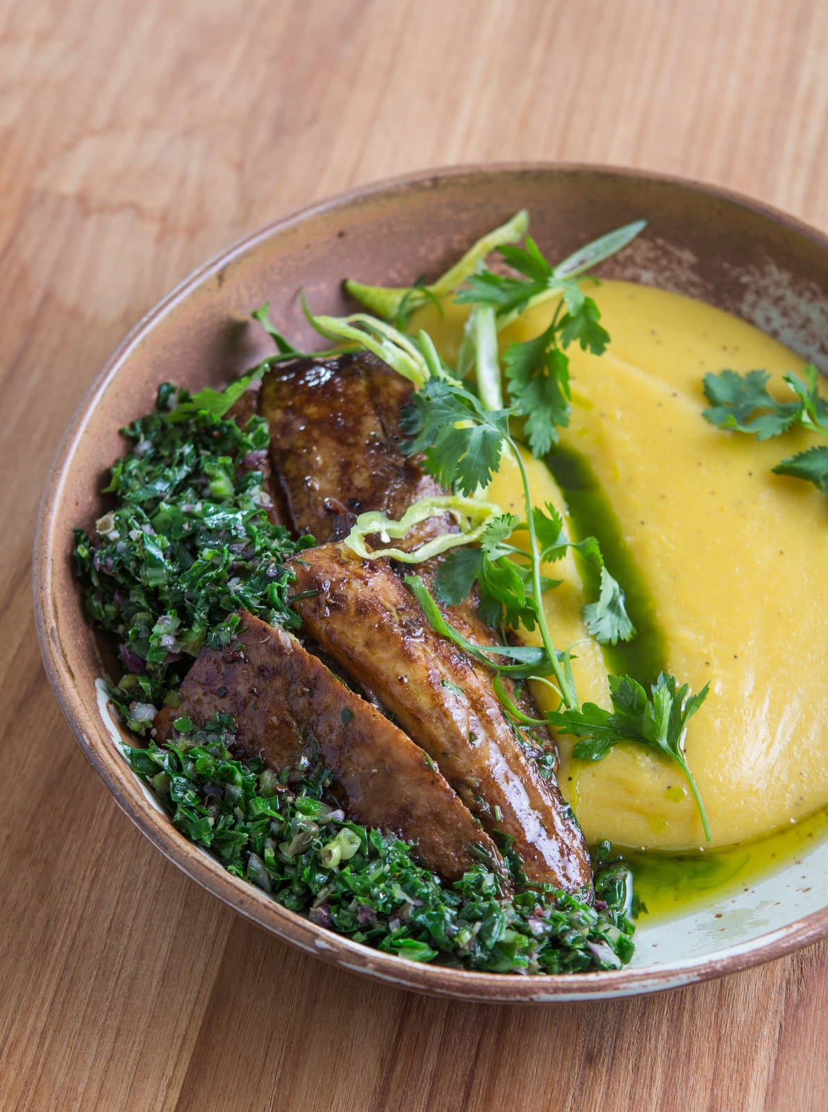 Wenn der Regenwald die Speisekarte schreibt, schmeckt man den Unterschied. Eine rustikale Keramikschale in der Cristalino Jungle Lodge mit karamellisierten Kochbananenscheiben, frischer Kräutersalsa und einem goldenen Püree, garniert mit Koriander