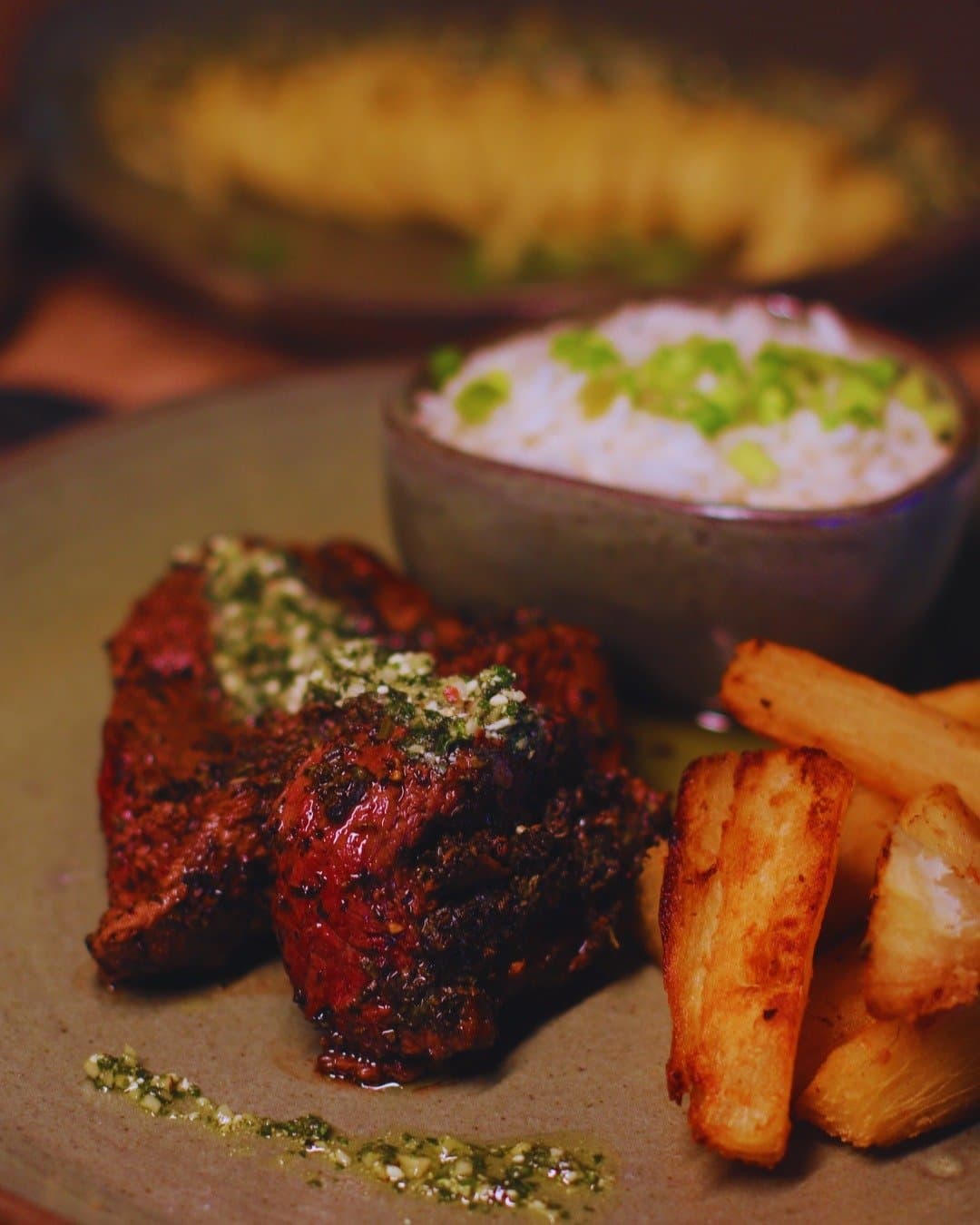 Nach einem Morgen auf dem Fluss schmeckt dieses Gericht einfach besser. Kräuterkrustiertes Grillfilet mit Chimichurri, frittierter Maniok und Reis mit Frühlingszwiebeln, serviert in der Juma Amazon Jungle Lodge