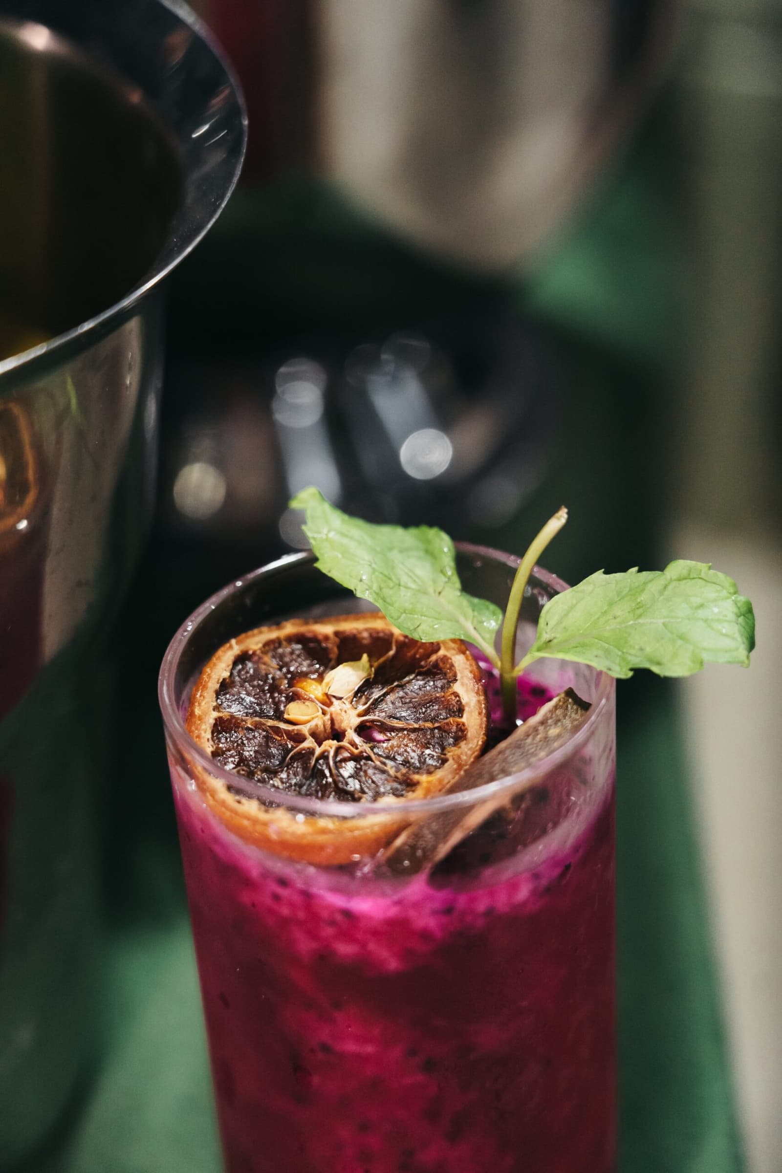 Aperitif auf dem Fluss, und zwar mit Sorgfalt gemacht. Ein leuchtend magentafarbener Cocktail im Highball-Glas, garniert mit einer getrockneten Zitrusscheibe und frischen Minzblättern, wird auf einer Amazonas-Kreuzfahrt in Brasilien eingeschenkt