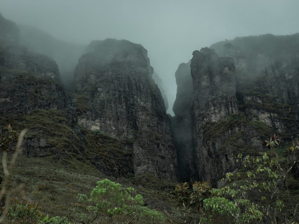 Paredões rochosos íngremes e imponentes parcialmente cobertos por uma névoa espessa no Parque Nacional do Pico da Neblina. Paredões rochosos íngremes e imponentes parcialmente cobertos por uma névoa espessa no Parque Nacional do Pico da Neblina.