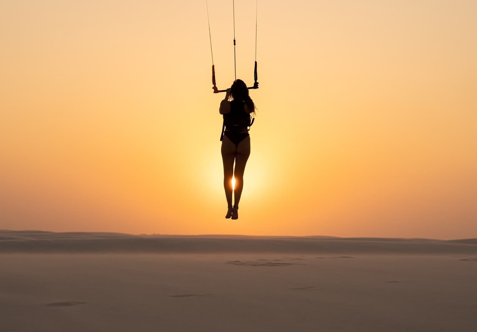 Caught mid-air, the kite doing all the work, the horizon endless beneath her feet. Photo 6