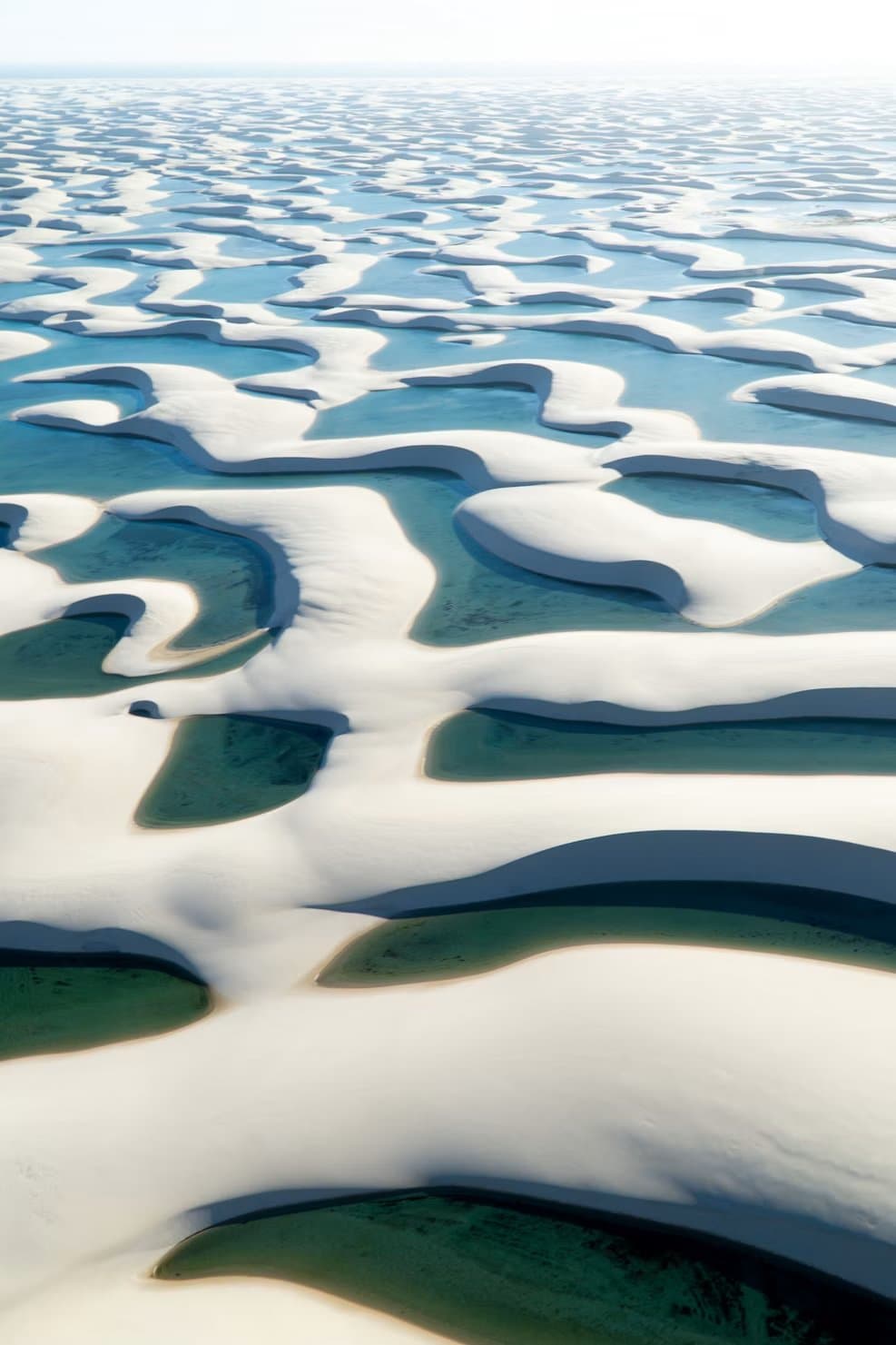 An endless mosaic of white dunes and crystal lagoons, seen from above. Photo 1