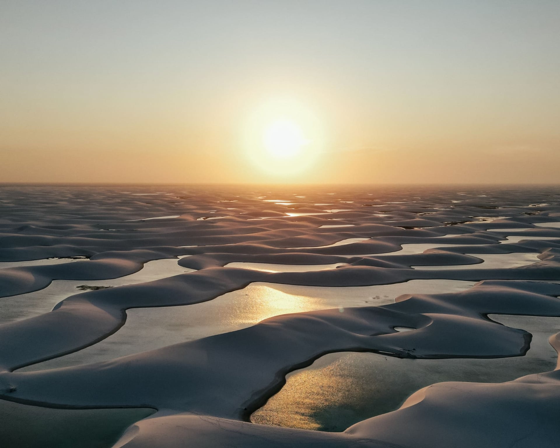 Aerial view of the white sand dunes and rainwater lagoons of Lençóis Maranhenses at sunset, Brazil. Aerial view of the white sand dunes and rainwater lagoons of Lençóis Maranhenses at sunset, Brazil.