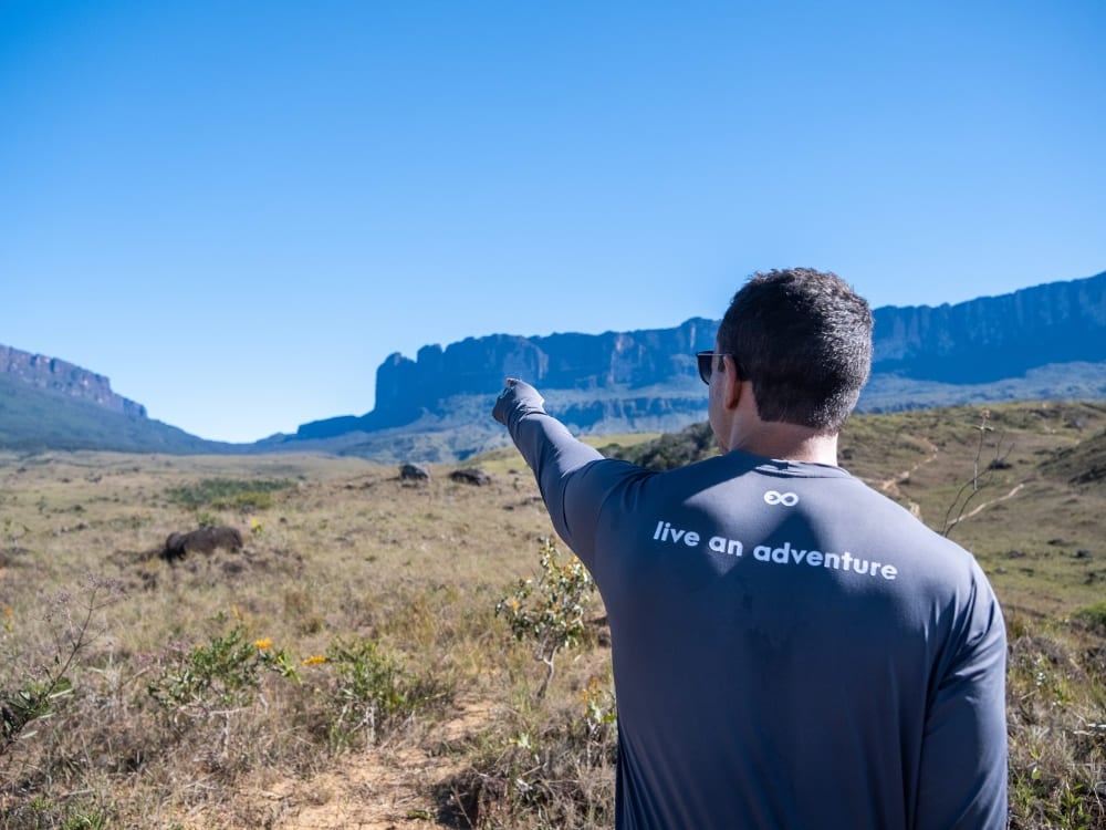 Un escursionista indica la vista sul tepui Kukenán dal Monte Roraima Un escursionista indica la vista sul tepui Kukenán dal Monte Roraima